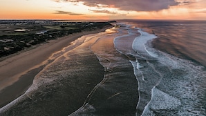 Un paisaje costero con una playa arenosa y olas del océano.