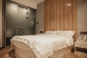 A bedroom with a bed, a wooden nightstand, a wooden wardrobe, and a wall-mounted light. - Fangorn International Hostel (Chongqing)