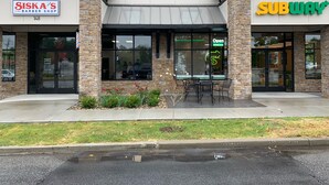 Un edificio con una barbería y un restaurante Subway.