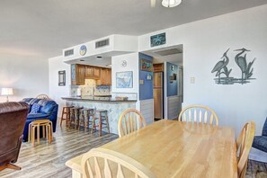 Un espace de vie compact comprenant une cuisine, un coin repas et un salon.