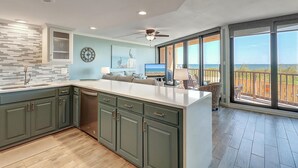 Cocina moderna con una isla grande, comedor con vistas y un balcón con vistas.