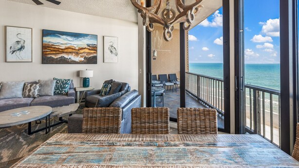 A spacious living area with a view of the ocean, furnished with a sofa, chairs, and a coffee table. - Sea Gull #1110: Beachfront 3 Bedroom 2.5 Bathroom With Spectacular Views and 24 Hour Management (Port Aransas)