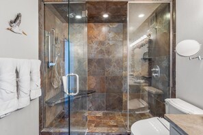 Een moderne badkamer met een douchecabine van glas, een toilet en een wastafel.
