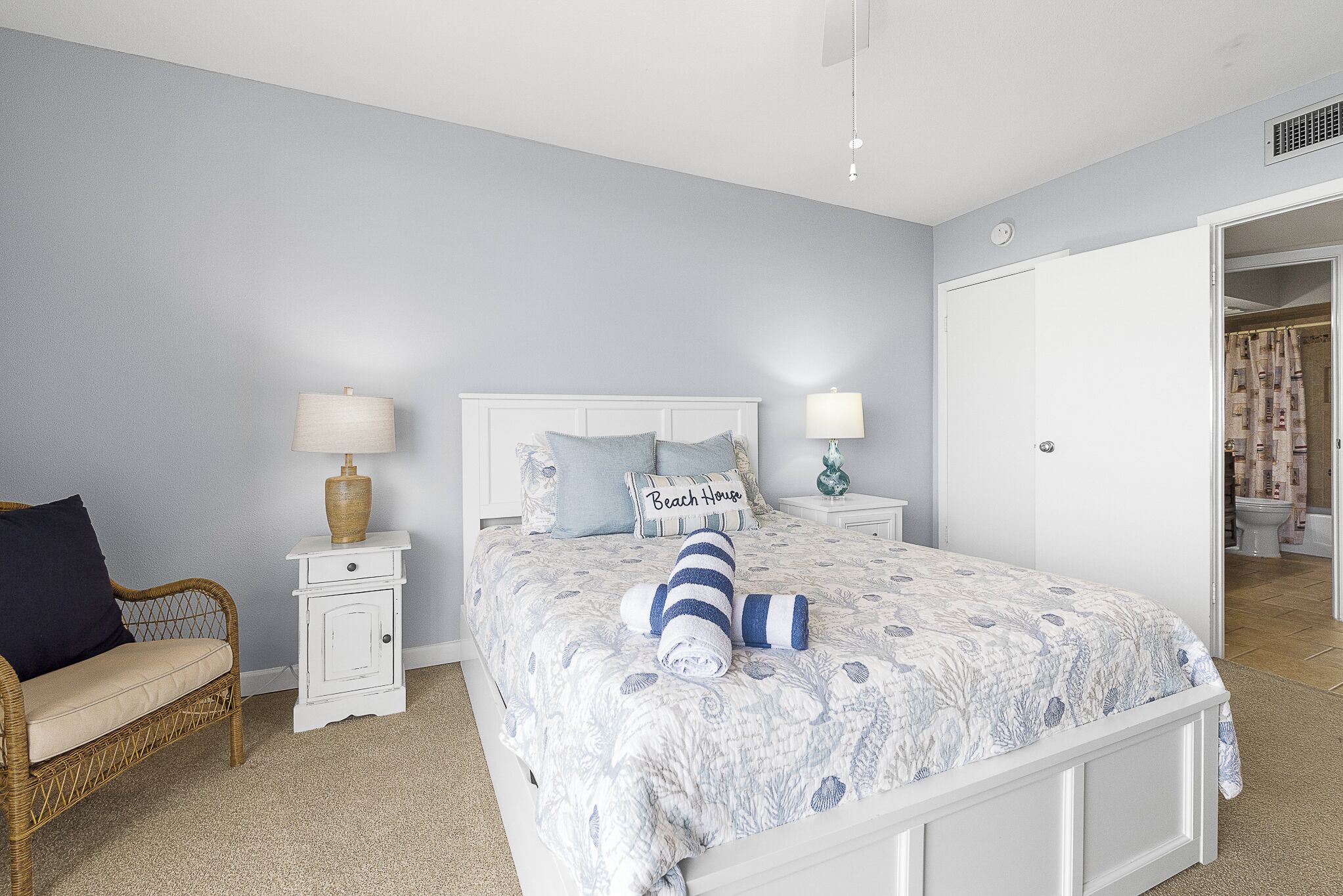 A bedroom with a bed, nightstands, a chair, and a wardrobe.