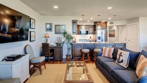 A modern living room with a sofa, coffee table, and a television. - Sea Gull #202: Beachfront 2 Bedroom 2 Bathroom With Spectacular Views and 24 Hour Management (Port Aransas)