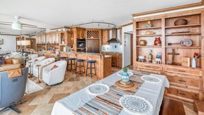 Cocina amplia con armarios de madera, una isla central y taburetes de bar.
