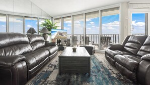 A spacious living room with leather sofas, a wooden coffee table, and large windows with blinds. - Sea Gull #509: Beachfront 2 Bedroom 2 Bathroom With Spectacular Views and 24 Hour Management (Port Aransas)