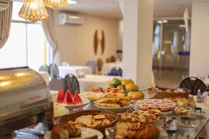 A buffet table with various food items and a grill in a modern dining area. - Hotel Del Principe (Maraba)