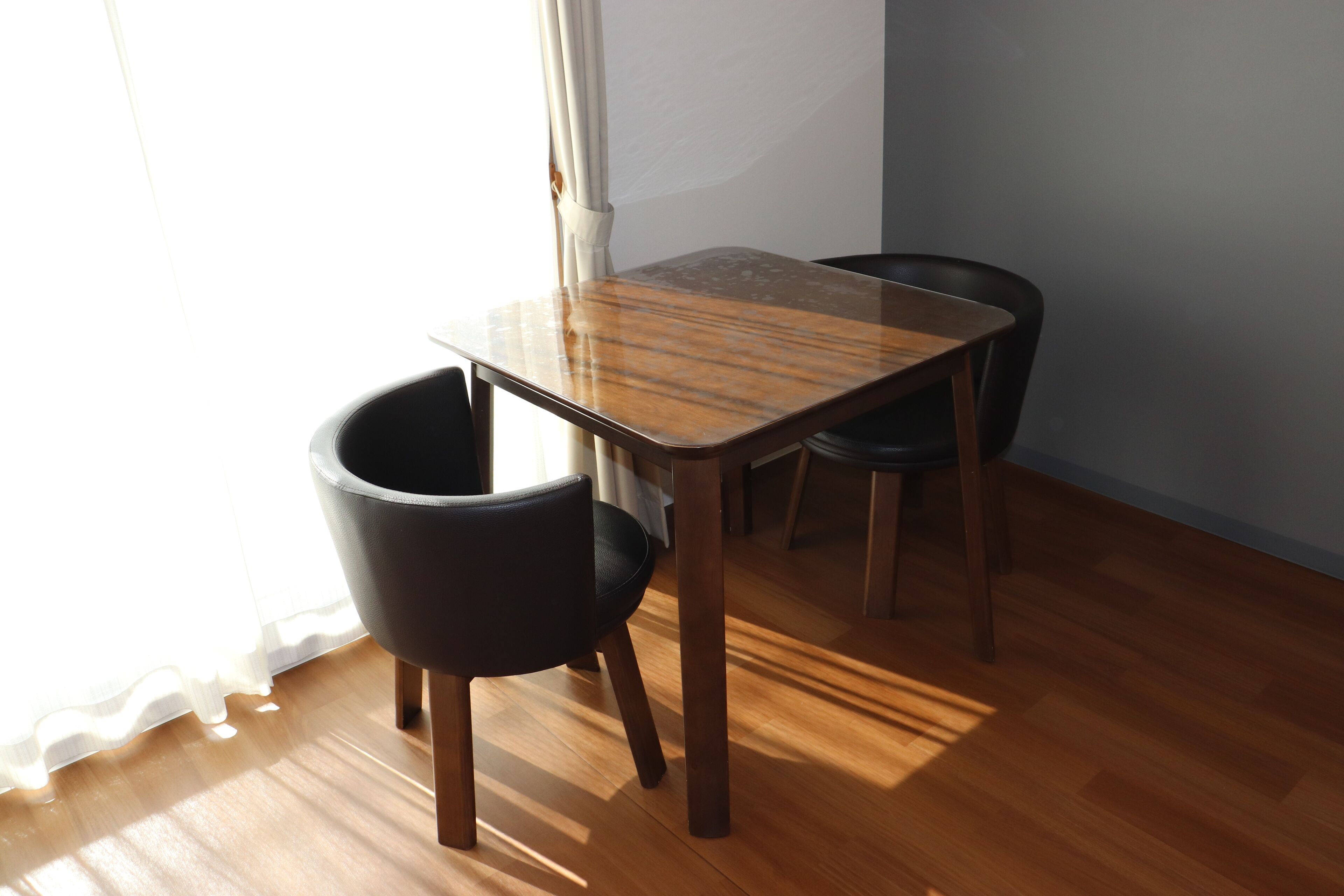 Un comedor con una mesa de madera y dos sillas.