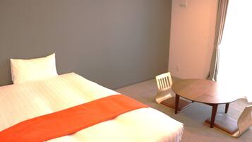 Una habitación de hotel con una cama, una mesita y una silla.