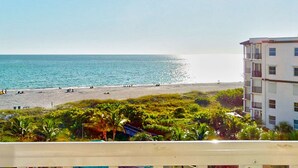 A beach with a view of the ocean and a building with balconies. - Family Vacay-Beach Days, Pool Time, Hot Tub, Spectacular Views. Beachfront Pools and Bar, Cafe, Gym (Treasure Island)