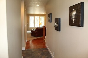 Enter a stylish hallway leading to a cozy living area with a sofa and coffee table.