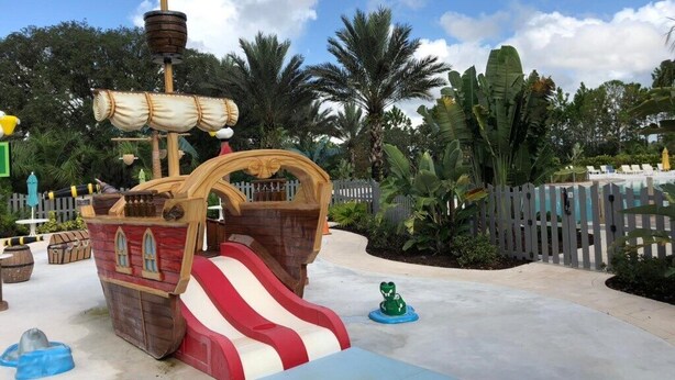 Zona de juegos temática pirata con un tobogán y una estructura de barco.