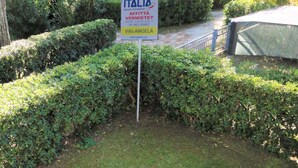 Schild für 'Italia Immobiliare' mit Werbung für ein Objekt namens 'Villa Angela' und Kontaktdaten.