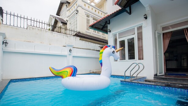 A swimming pool with a white inflatable unicorn float. - DREAM HOUSE VILLA Vung Tau (Tp. Vũng Tàu)