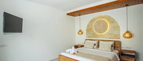 A bedroom with a bed, bedside tables, a wall-mounted TV, and a unique circular light fixture.