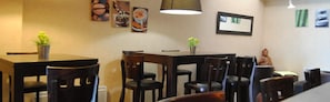A dining area with a table and chairs, a hanging lamp, and wall art. - Castel de Mirambel (Lourdes)