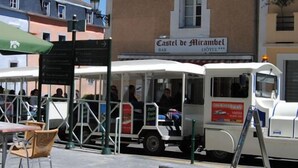 Sitzgelegenheiten im Freien mit Sonnenschirmen, ein Food-Truck und ein Hotelschild im Hintergrund.