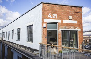 A building with a white facade and a brick section with the number 421. - Paintworks Apartments (Bristol)