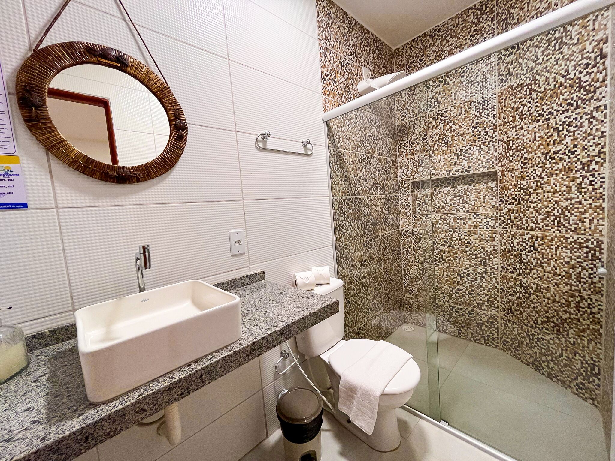 A bathroom with a white sink, a toilet, and a glass shower enclosure.