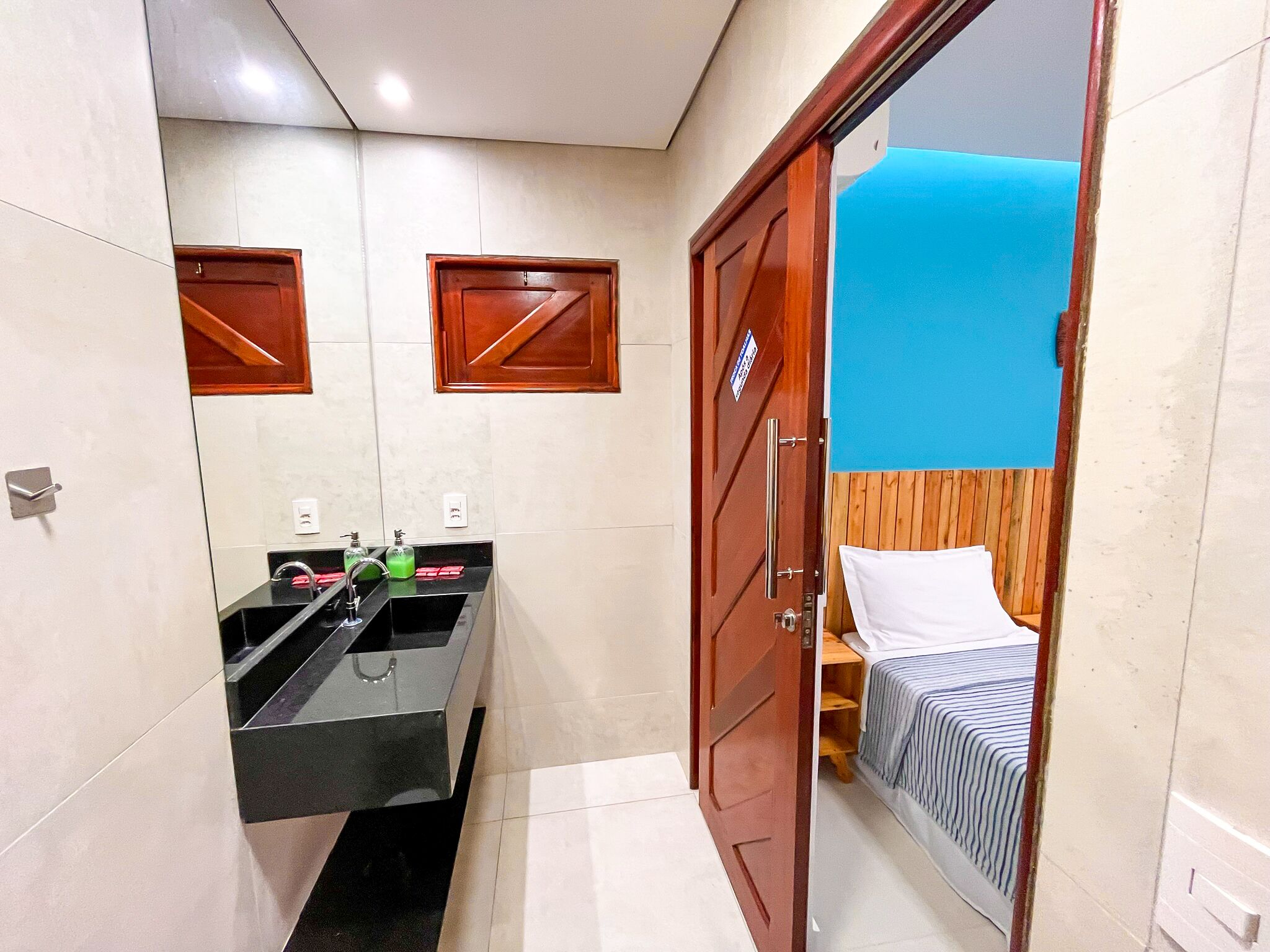 A bathroom with a sink, mirror, and two towel racks.