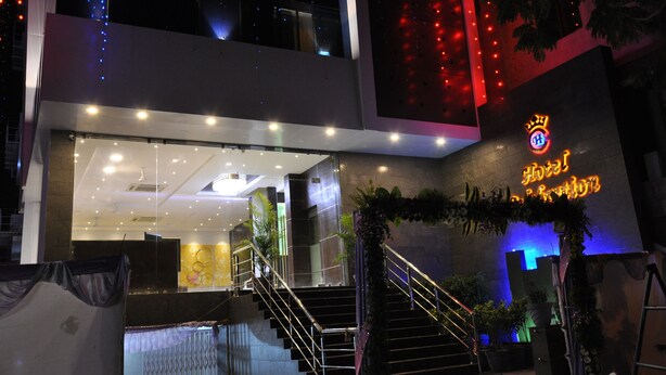 Una entrada de hotel moderna con una escalera, un área de recepción y un letrero de neón.