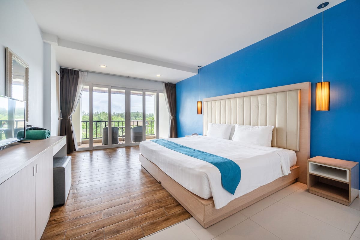 Una habitación de hotel moderna con una cama grande, un escritorio y vistas al exterior.