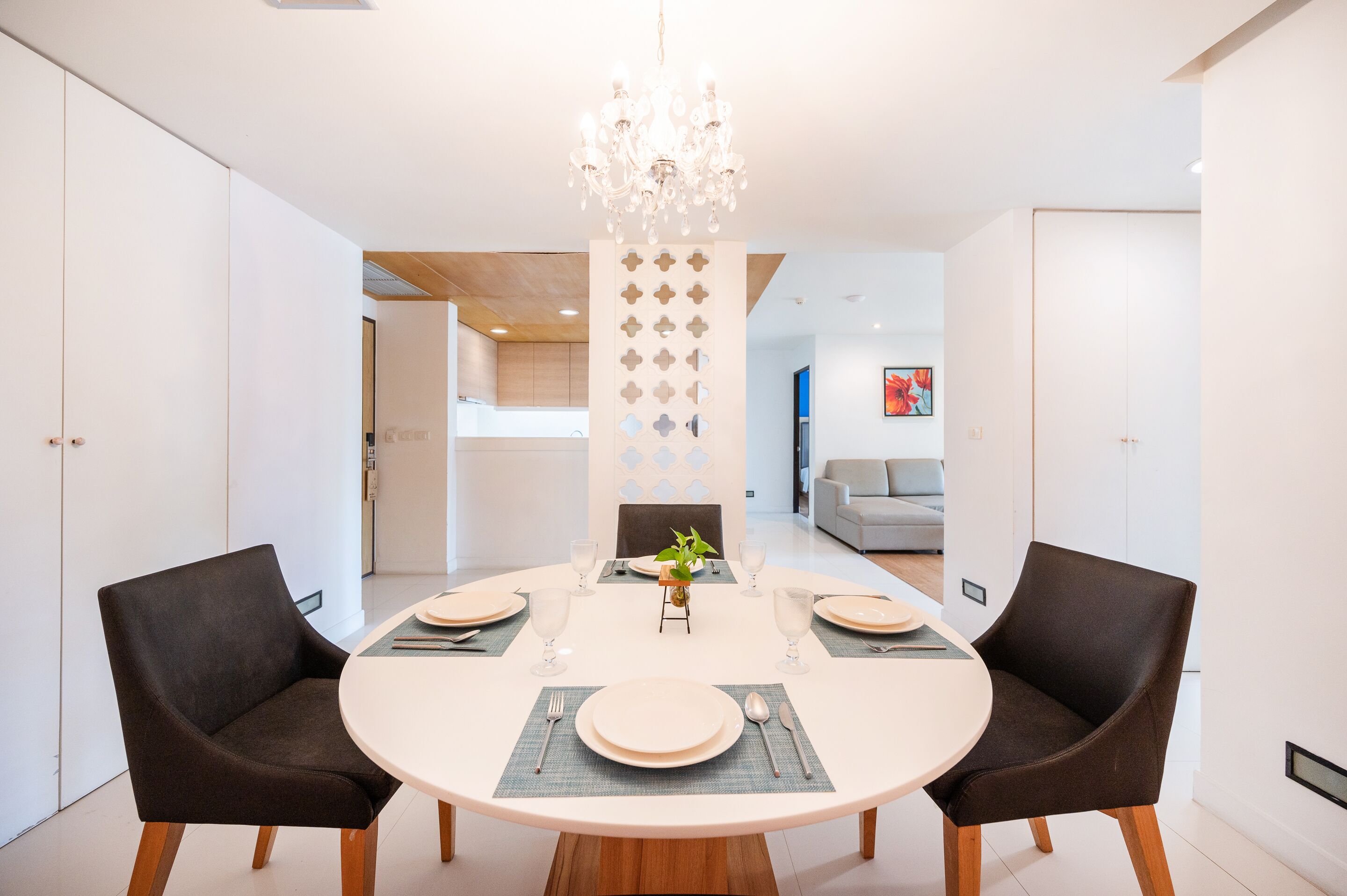 Un espace repas moderne avec une table ronde, deux chaises et un lustre.