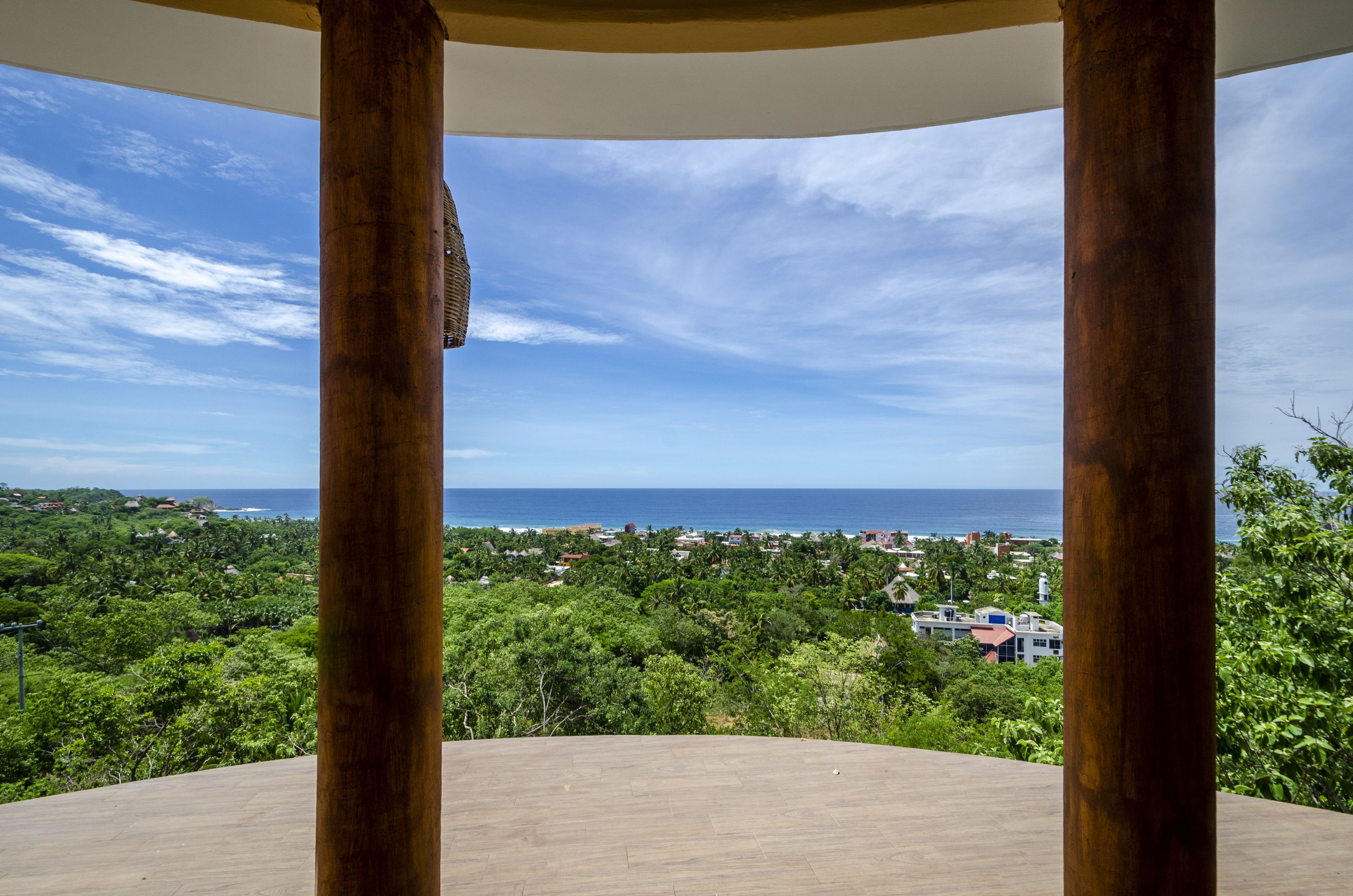 A wooden deck with a view of a coastal town and ocean.