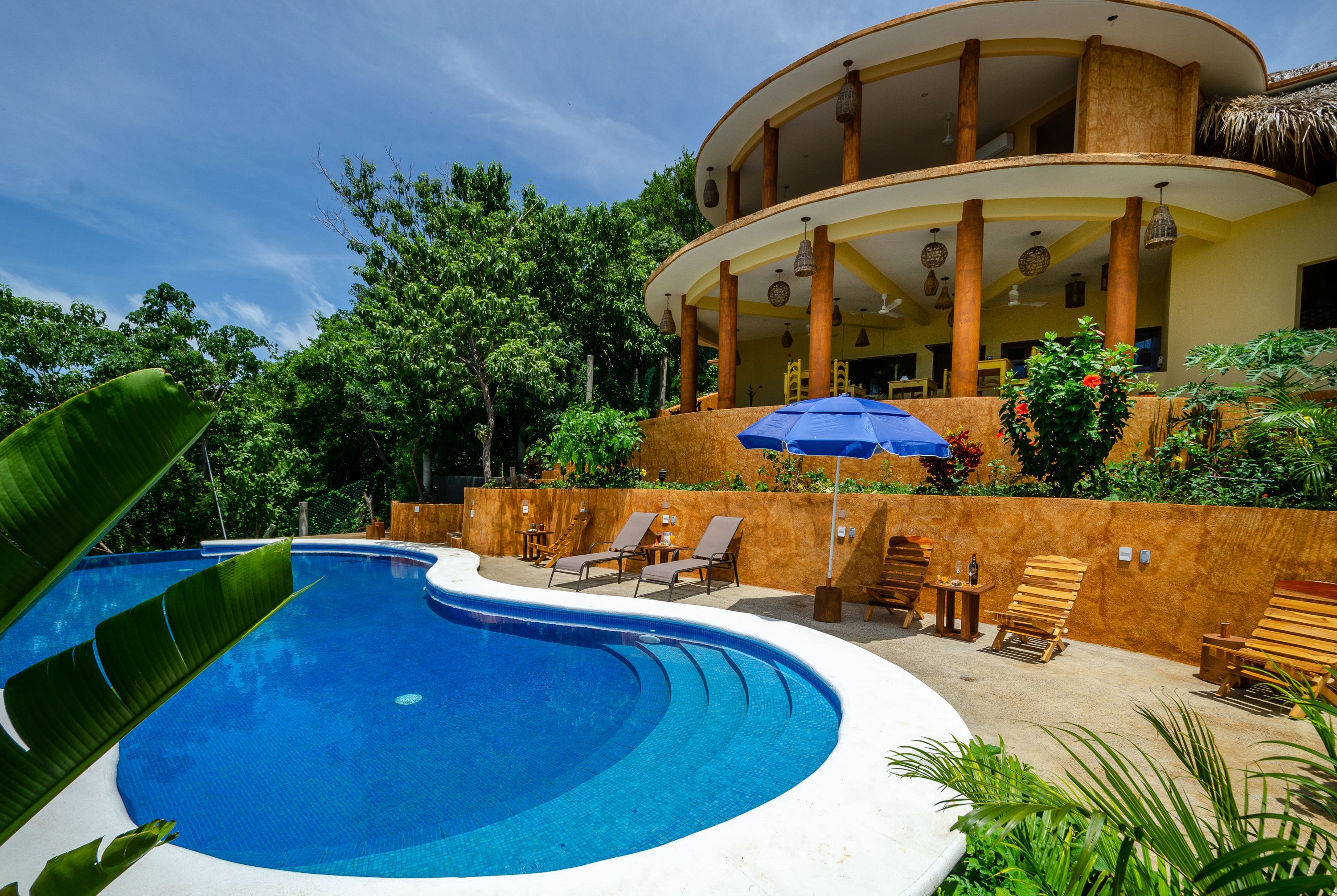 Una piscina al aire libre, camas de piscina gratis, sombrillas