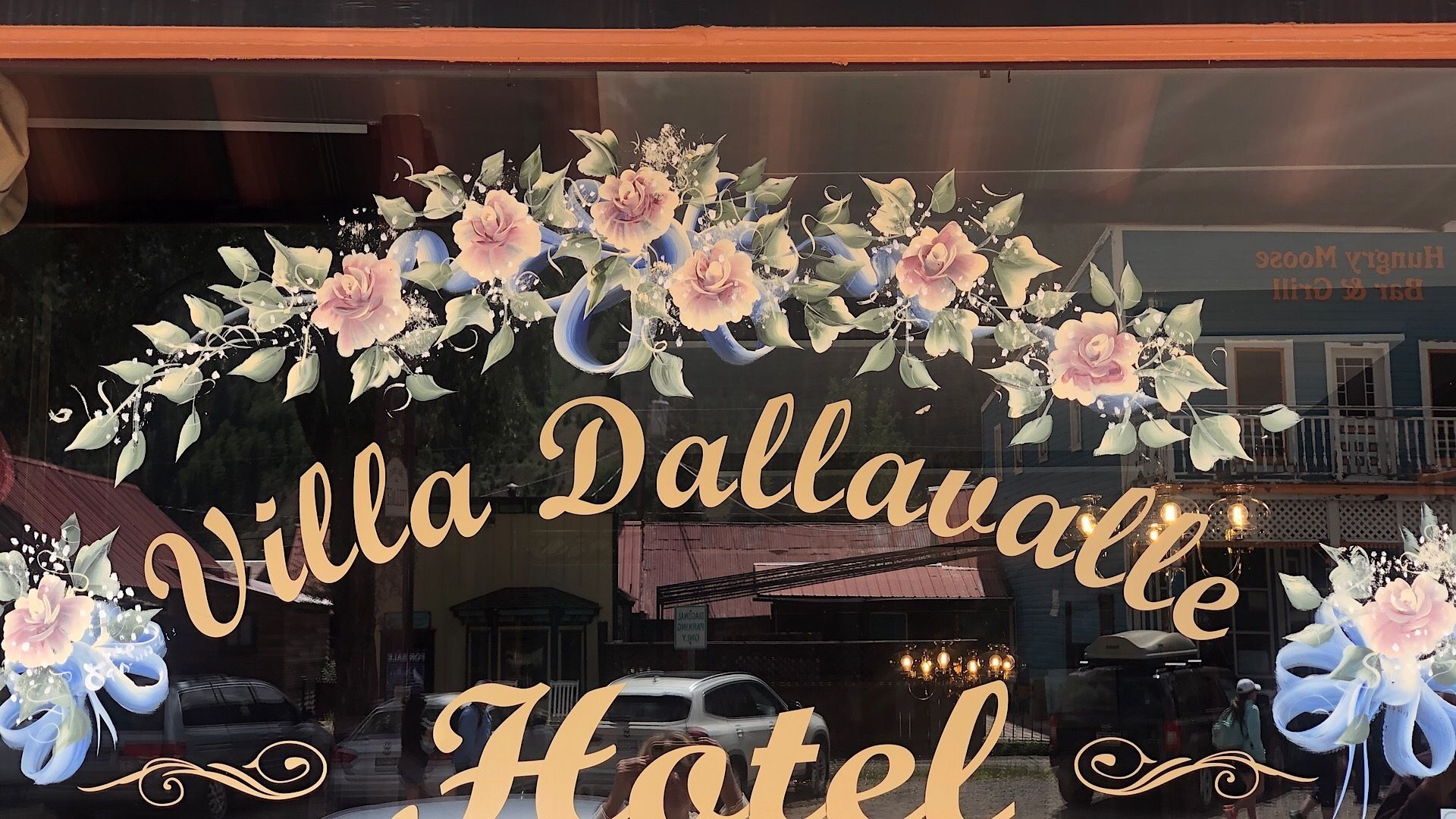 Ein Hotel Eingang mit einem floralen Bogen, auf dem deutlich der Name "Villa Dallavalle Hotel" zu sehen ist.