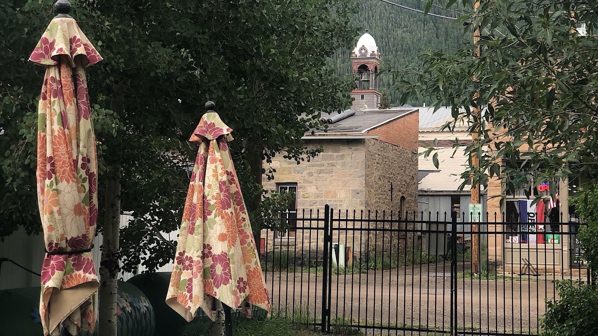 A fenced area with a building featuring a bell tower and a sign that reads "BENEVENIL."