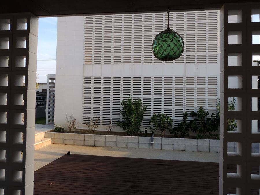 A building with a white exterior, a green spherical ornament, and a wooden deck.