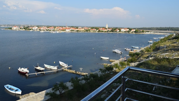 Un pueblo costero con un puerto deportivo, barcos y edificios a lo largo del frente marítimo.