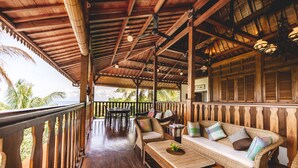 Eine Holzterrasse mit einer Couch, Stühlen und einem Tisch.