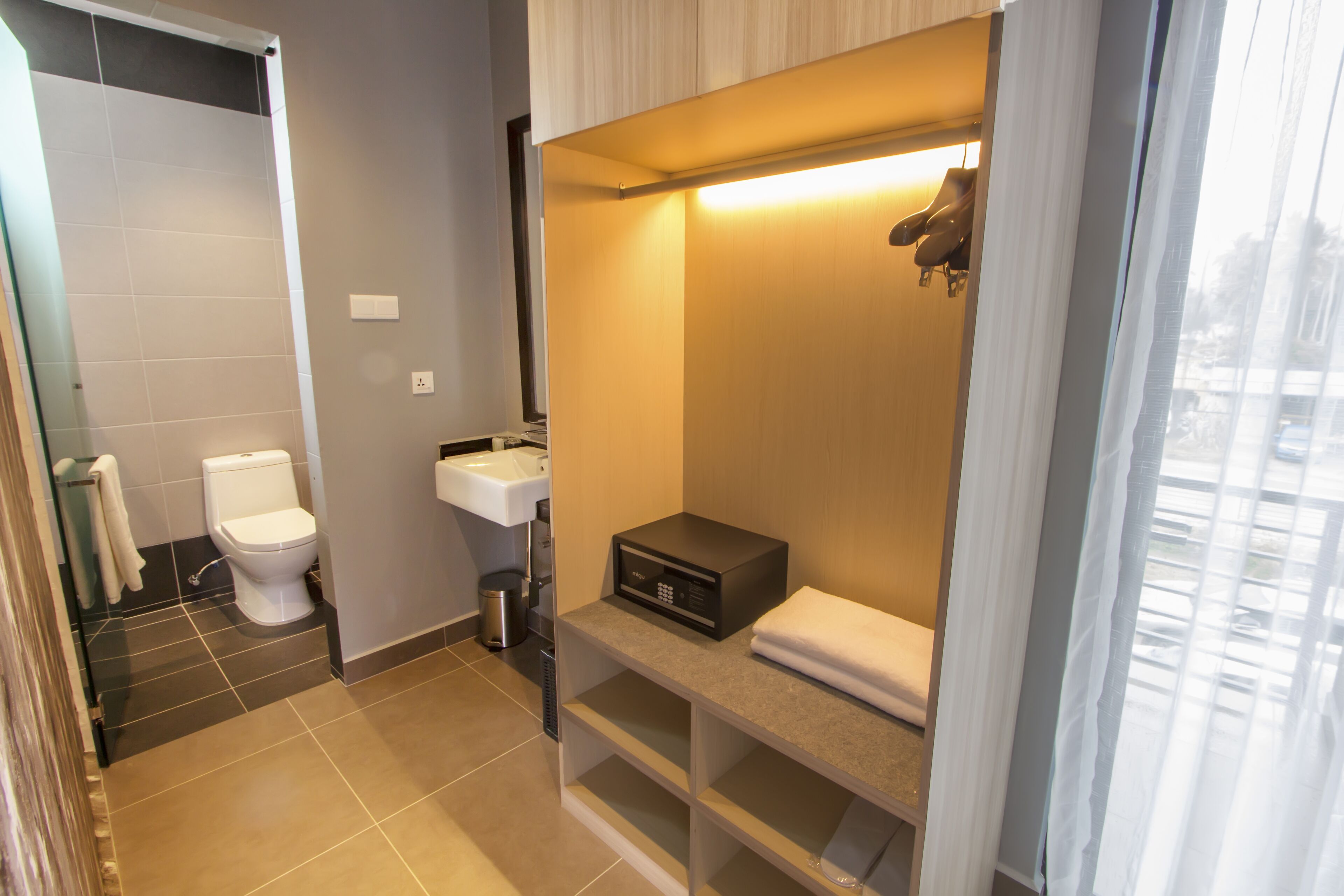 A compact bathroom with a toilet, sink, and a built-in heater.