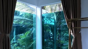 A room with a large glass door leading to a garden. - Phuc Sinh Homestay (Phu Tuc)