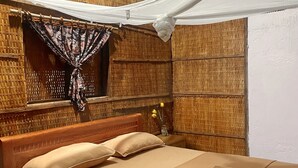 A bed with a canopy, wooden headboard, and a bedside table with a lamp. - Phuc Sinh Homestay (Phu Tuc)