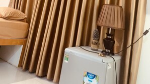 A room with a bed, a water dispenser, and a lamp on a table. - Phuc Sinh Homestay (Phu Tuc)