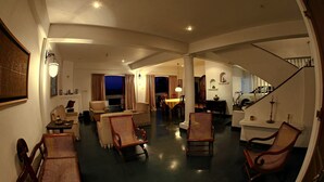 A spacious living room with a high ceiling, a staircase, and a dining area. - Primrose Bungalow (Kandy)