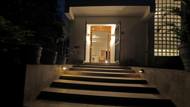 A staircase leading to a building entrance at night, with steps illuminated by wall-mounted lights. - Primrose Bungalow (Kandy)