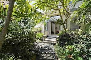 Un rigoglioso giardino con un vialetto in pietra che conduce all'ingresso di un edificio.