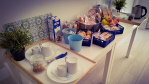 A breakfast table with various food items, a carton of milk, and a coffee maker. - AlbaChiara B&B (Gaeta)