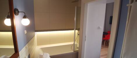 A modern bathroom with a bathtub, a sink, and a shower.