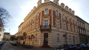 Um edifício histórico com estilo arquitetônico clássico, apresentando uma entrada imponente e várias janelas.