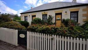 Een wit gebouw met een bord waarop staat 'Bridge Cottage'.