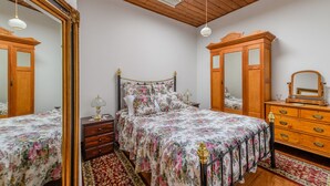 Een slaapkamer met een bed, een kaptafel, een spiegel en een dakraam.