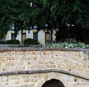 Un pont en pierre avec une arche au-dessus d’un mur de pierre.