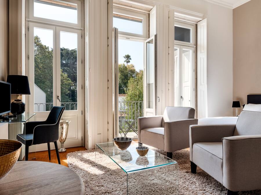 Chambre Quadruple Junior, vue jardin (Monica) | Coin séjour | Télévision de 22 pouces avec chaßnes par cùble, livres