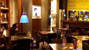 A hotel lobby with multiple tables and chairs, a bar area, and a large framed picture on the wall. - Radisson Blu Erfurt (Erfurt)